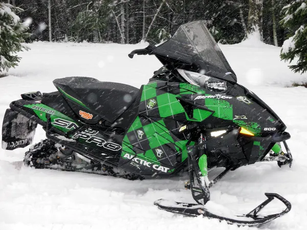 A Arctic Cat Proclimb snowmobile with a white, green, and black pattern Argyle custom vinyl wrap.