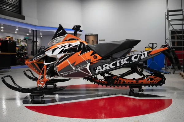 A Arctic Cat Procross snowmobile with a orange, white and black lightning Bolt custom vinyl wrap.