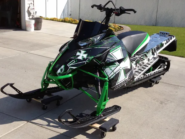 A Arctic Cat Proclimb snowmobile with a green, white and black grunge Medal of Honor custom vinyl wrap.