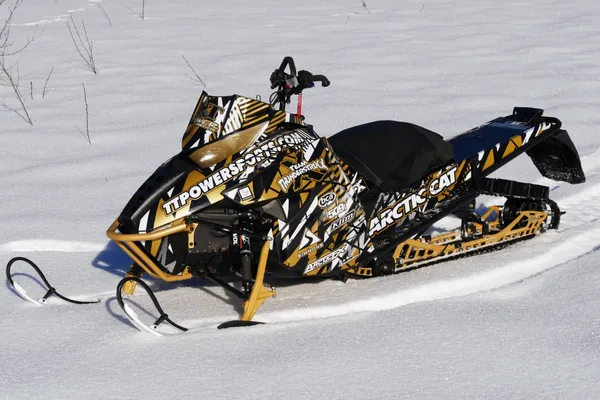 A Arctic Cat Procllimb snowmobile with a black, white, and gold grunge bolt Voltage custom vinyl wrap.