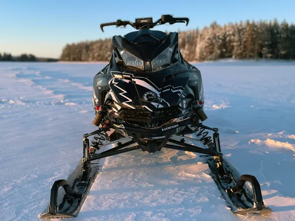 A Lynx snowmobile with a black, gray, and white Altitude custom vinyl wrap.
