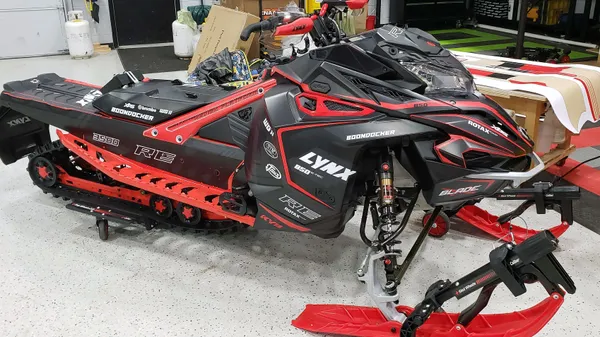A Lynx snowmobile with a black solid color custom vinyl wrap with stock logos added.