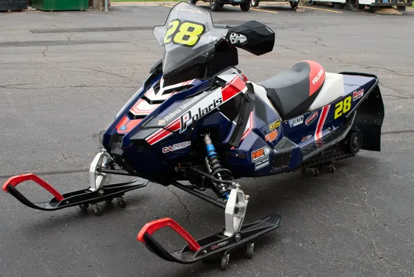 A Polaris Axys 600R snowmobile with a red, white, and blue retro Nelson racing custom vinyl wrap.