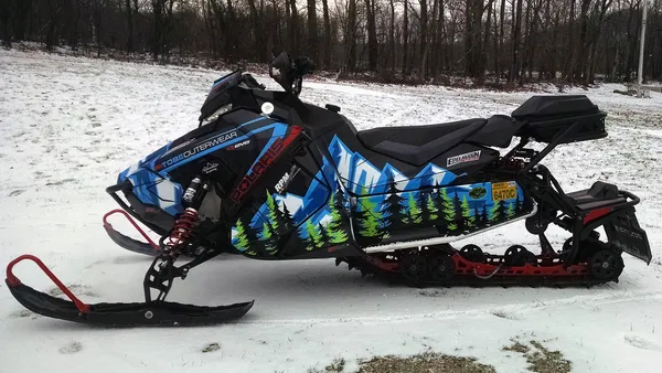 A Polaris Axys Trail snowmobile with a black, white, lime, and blue Sub Zero Mash Up custom vinyl wrap.