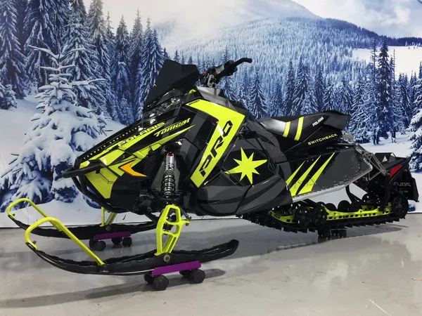 A Polaris Axys Trail snowmobile with a black and lime squeeze racing stripes Relay custom vinyl wrap.