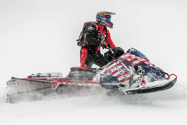 A Polaris Matryx Mountain snowmobile with a red white and blue Klim We The People custom vinyl wrap.