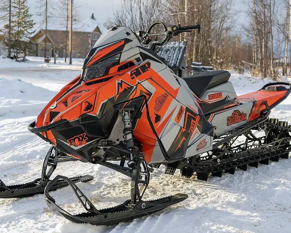 A Polaris Matryx Mountain snowmobile with a orange, gray, and black Teton custom vinyl wrap.
