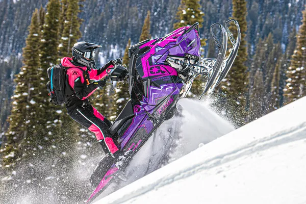 A Polaris Matryx Mountain snowmobile with a purple, pink, and black Teton custom vinyl wrap.