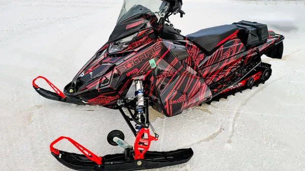 A Polaris Matryx Trail snowmobile with a red and black grunge lines Dangerzone custom vinyl wrap.